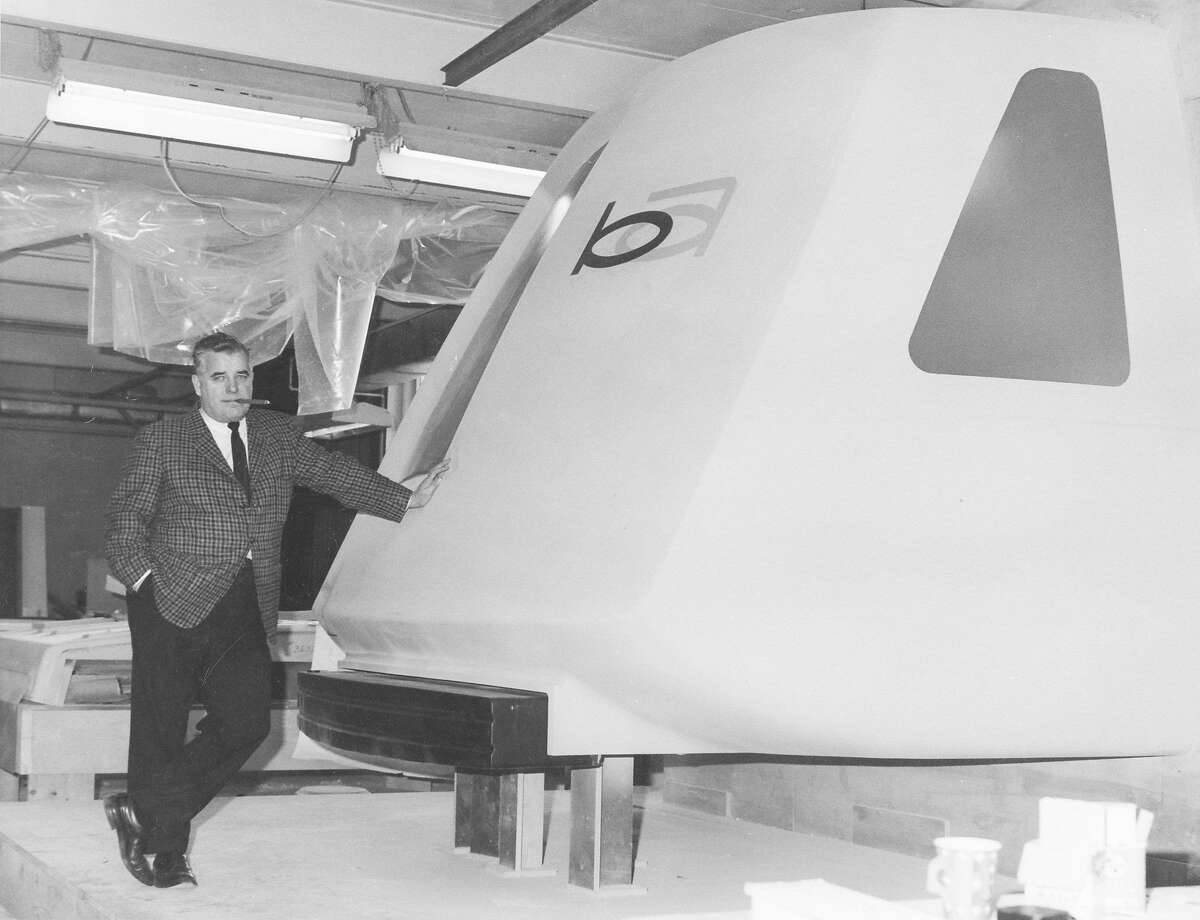 A Bay Area Rapid Transit official leans on a model BART car in 1965.