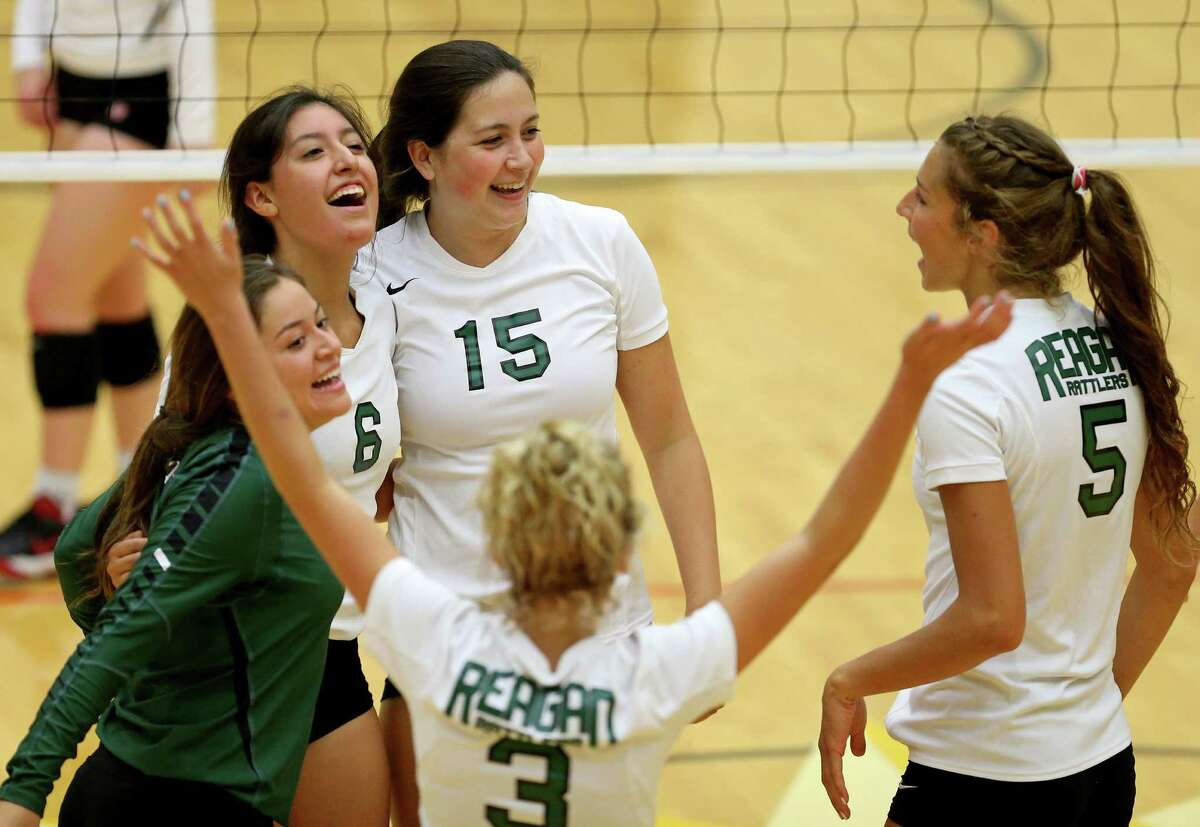 Reagan players celebrate after a point against Brennan during their season opening match Monday Aug. 8, 2016 at Littleton Gym. Reagan won 25-17, 25-13, 25-22.