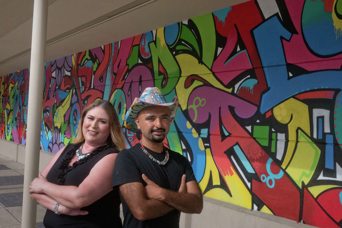 Artist Gonzo247 and Pamela Vargas, Rice Village assistant general manager, stand before Gonzo247's mural "It's a Good Day to Have a Good Day," painted on a wall next to the Black Walnut Café, 5510 Morningside Drive.