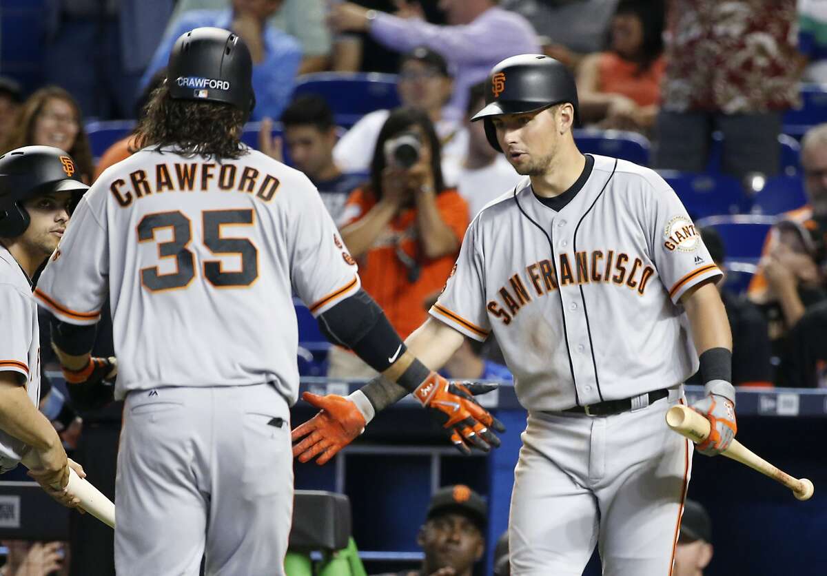 San Francisco Giants' Brandon Crawford (35) is congratulated by Joe Panik after Crawford hit a home run during the fourth inning of a baseball game against the Miami Marlins, Wednesday, Aug. 10, 2016, in Miami. The Giants defeated the Marlins 1-0. (AP Photo/Wilfredo Lee)