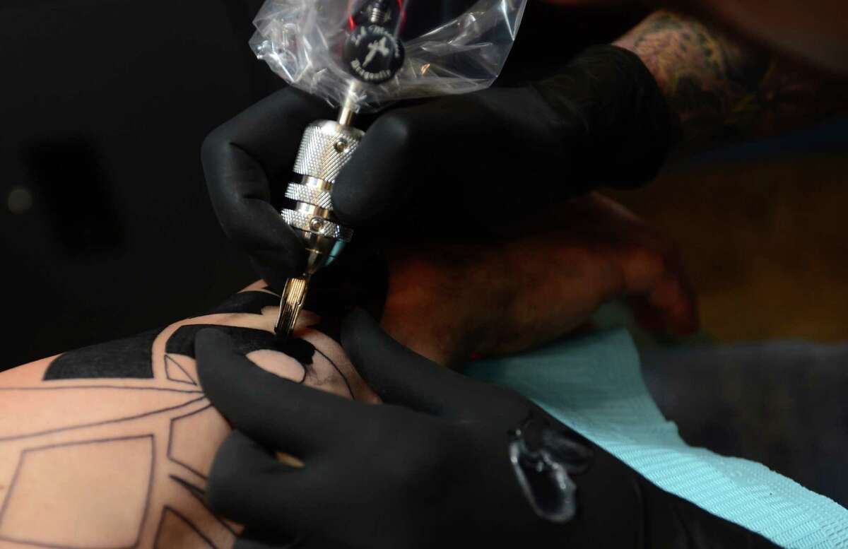 Pieter Spijkers, an artist at Bad Fish Tattoo, inks a tribal tattoo for client Eric Monaco at the shop in Liberty Plaza in Norwalk.