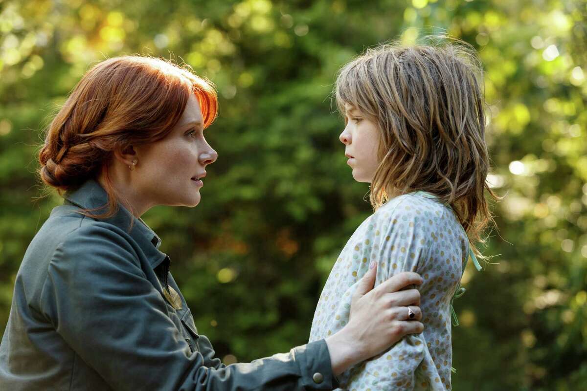 This image released by Disney shows Bryce Dallas Howard, left, and Oakes Fegley in a scene from "Pete's Dragon." (Matt Klitscher/Disney via AP)