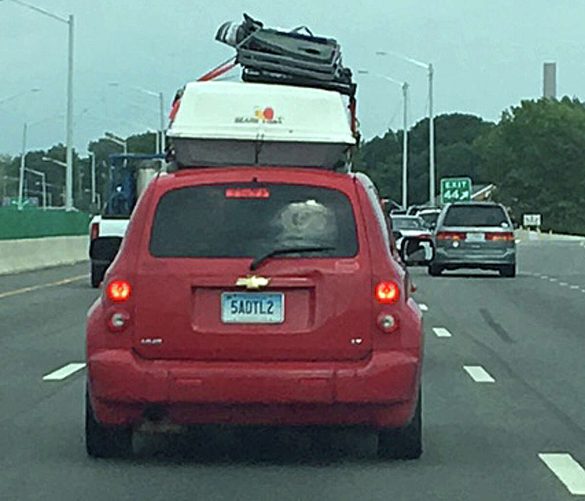 A car loaded with cargo on top of its roof travels on I-95 in New Haven.