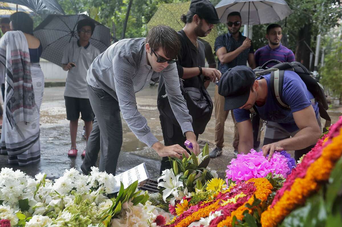 People offer flowers to pay their respects to the victims of the attack on Holey Artisan Bakery, in Dhaka, Bangladesh, Tuesday, July 5, 2016. The attack, the worst convulsion of violence yet in the recent series of deadly attacks to hit Bangladesh, has stunned the traditionally moderate Muslim nation and raised global concerns about whether it can cope with increasingly strident Islamist militants. (AP Photo)