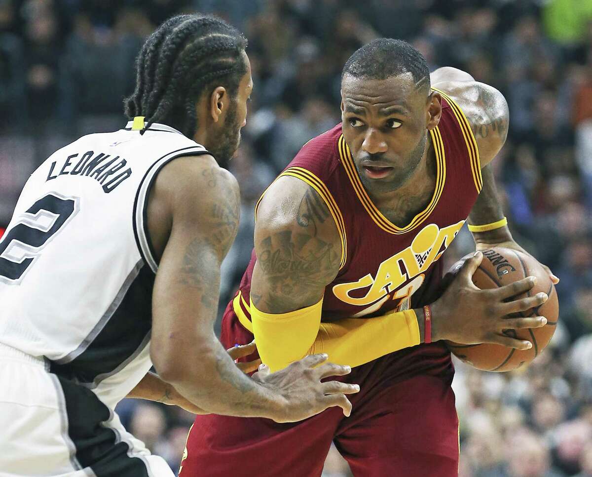 LeBron James stops at the top of the key to size up the defense by Kawhi Leonard as the Spurs host the Cavaliers at the AT&T Center on January 14, 2016.