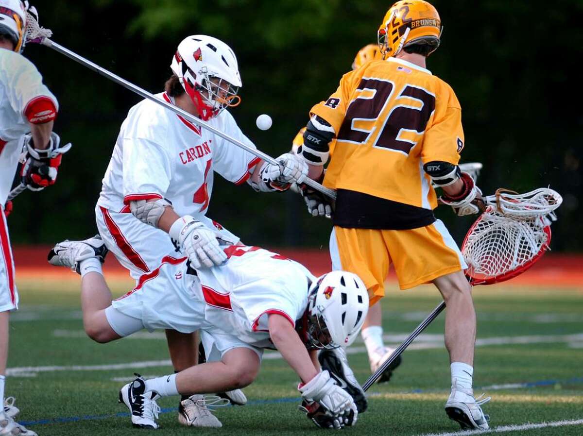 Greenwich High School goalie, Ryan Fisher, tumbles to the ground as teammate, Adam Sands, # 4, left, fights John Kelly, # 22, of Brunswick for the ball during late game action at GHS, Thursday, April, 29, 2010. The Bruins defeated the Cardinals, 15-7.
