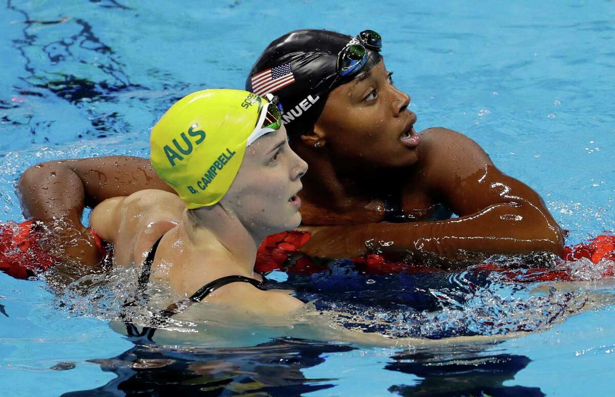 United States' Simone Manuel, right, looks at the scoreboard with Australia's Bronte Campbell and wins the gold medal setting a new olympic record in the women's 100-meter freestyle during the swimming competitions at the 2016 Summer Olympics, Thursday, Aug. 11, 2016, in Rio de Janeiro, Brazil. (AP Photo/Natacha Pisarenko)