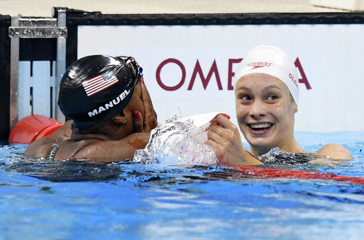 Canada's Penny Oleksiak, right, and United States' Simone Manuel react to their tie for gold in the women's 100-meter freestyle final during the Olympic Summer Games in Rio de Janeiro, Brazil, on Thursday, Aug. 11, 2016. (Sean Kilpatrick/The Canadian Press via AP)
