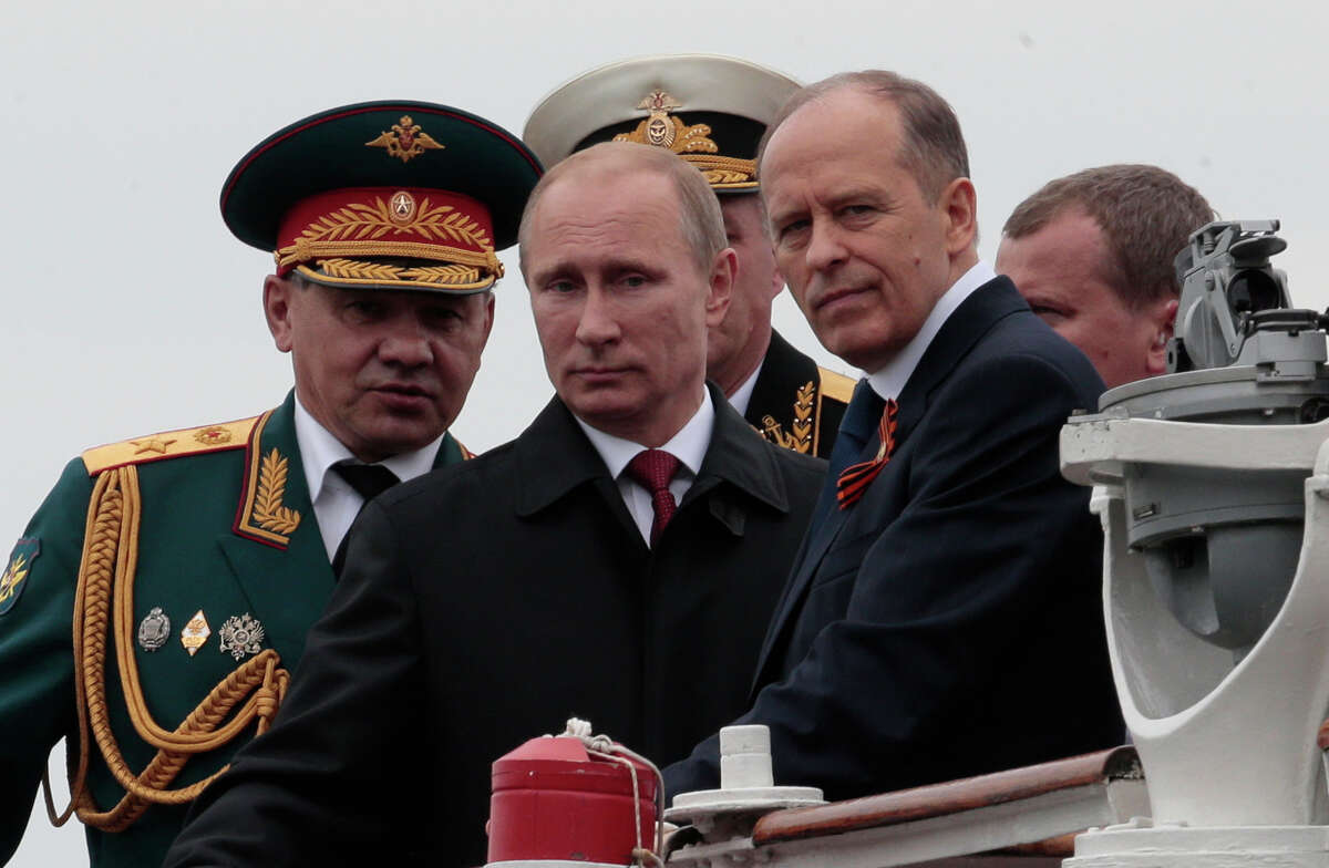 In this file photo taken on Friday, May 9, 2014, Russian President Vladimir Putin, centre, flanked by Defense Minister Sergei Shoigu, left, and Federal Security Service Chief Alexander Bortnikov, right, arrives on a boat after inspecting battleships during a navy parade marking the Victory Day in Sevastopol, Crimea.