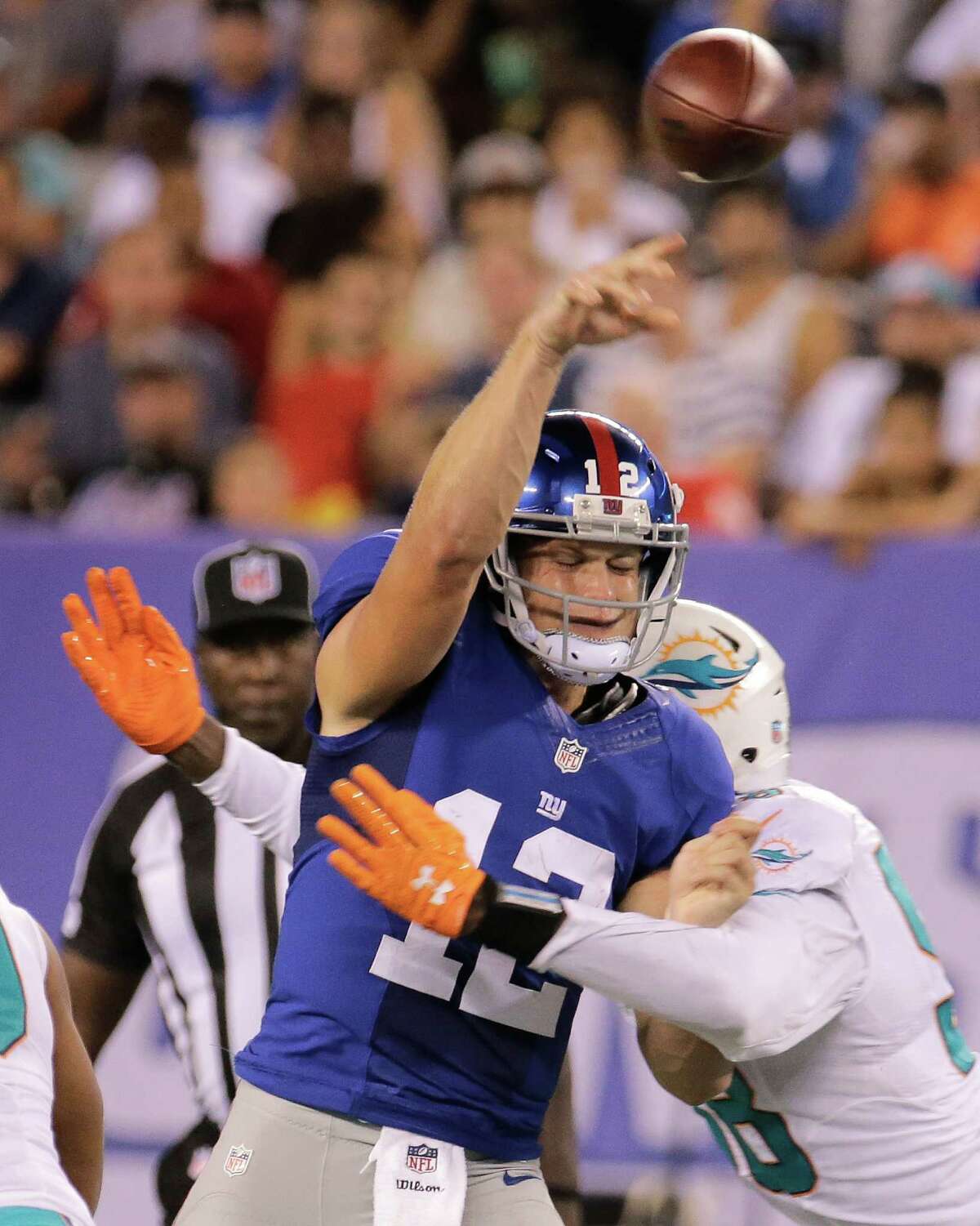 New York Giants quarterback Ryan Nassib (12) is hit by Miami Dolphins defensive end Chris McCain (58) during the first quarter of an NFL football game, Friday, Aug. 12, 2016, in East Rutherford, N.J. (AP Photo/Ray Stubblebine) ORG XMIT: ERU106