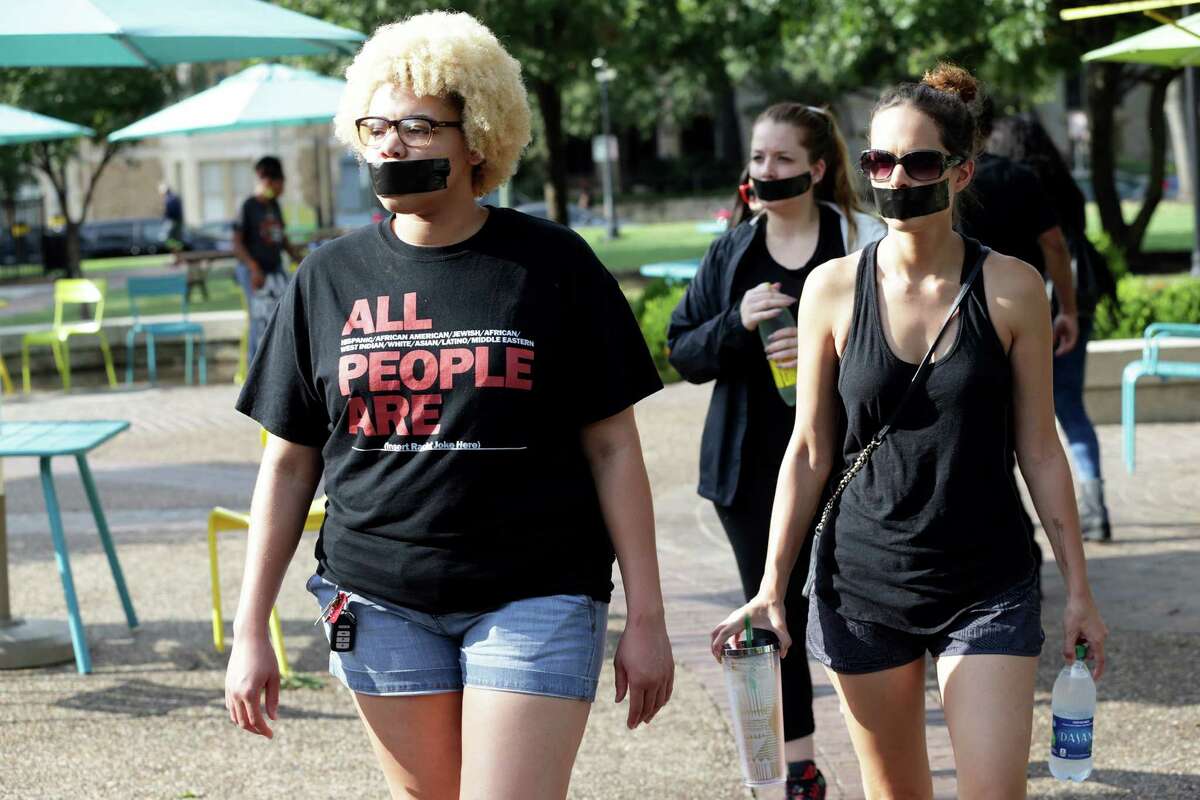 Marches walk into the Travis Park where local activists conduct a silent protest to express their views about police interaction on August 13, 2016