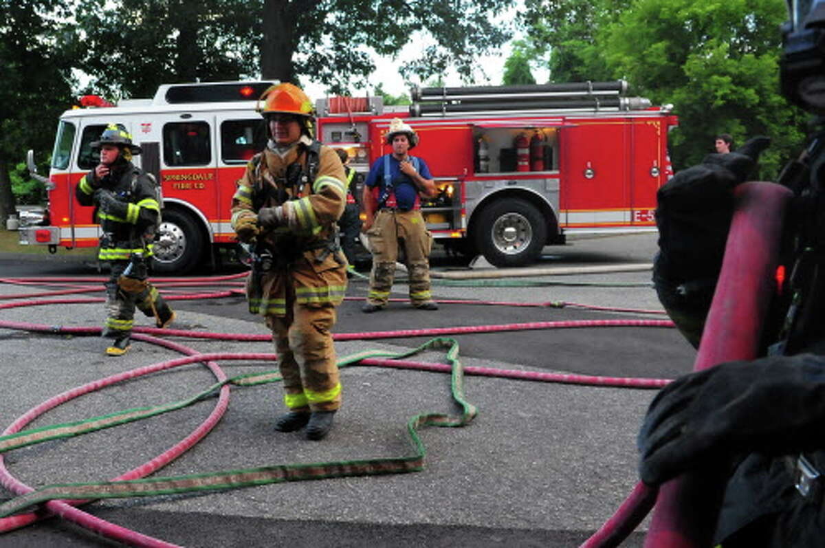 Volunteer firefighter recruits from Stamford train in a variety of firefighting techniques inside and outside of the fire training facility behind the Darien Town Yard in Darien, Conn., on Thursday Aug. 6, 2015. Some of the drills included hose line advancement practice into a simulated fire as well as search and rescue operations.
