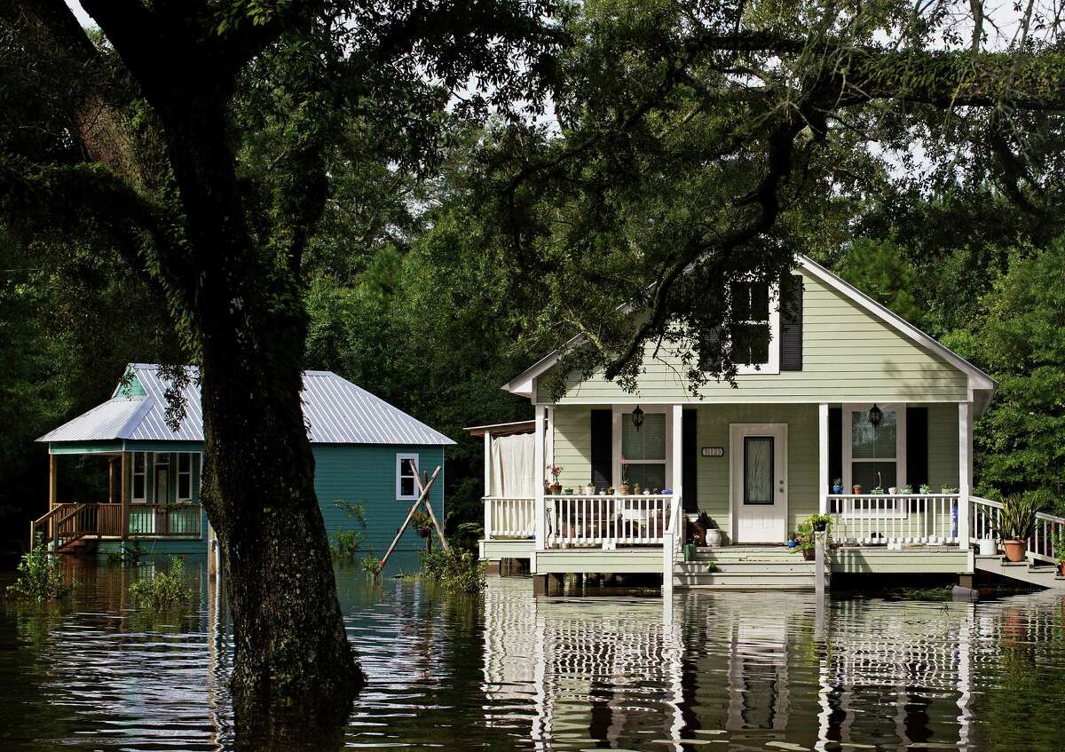 Floodwaters reach the front steps of homes built on pillars near Holden, La., after heavy rains inundated the region, Sunday, Aug. 14, 2016. Louisiana Gov. John Bel Edwards said Sunday that at least 7,000 people have been rescued so far.