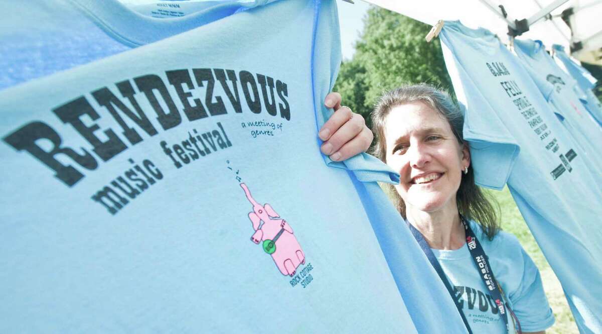 Tracy Sennett of Redding sells Rendezvous T-shirst at the music festival held at Ives Concert Park in Danbury. Sunday, Aug.14, 2016