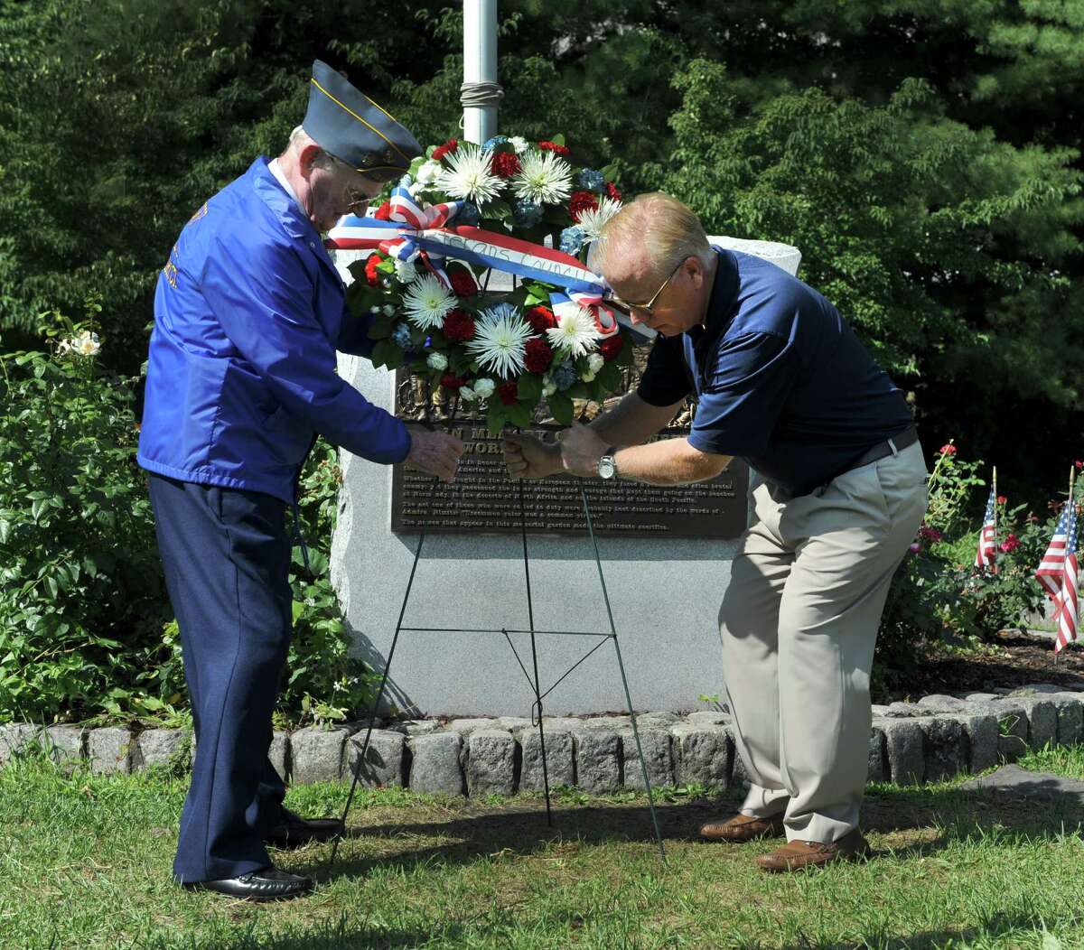 John Edmond, left, 90, of Danbury, who served on the U.S. Providence during World War II and Mayor Mark Boughton, place a wreath at the War War II monument Monday morning. A ceremony at the Rogers Park Rose Garden marked the 71 st anniversary of the Japanese surrender and the end of World War II, Monday, August 15, 2016 in Danbury.