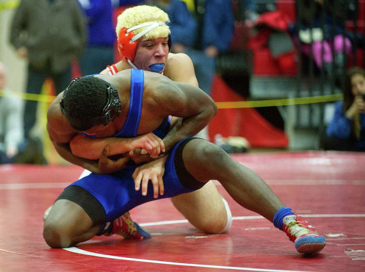 Xavier Bass of Harding competes against Johnny Garcia of Danbury, who won the match, during Saturday's FCIAC wrestling championship finals at New Canaan High School on February 14, 2015.