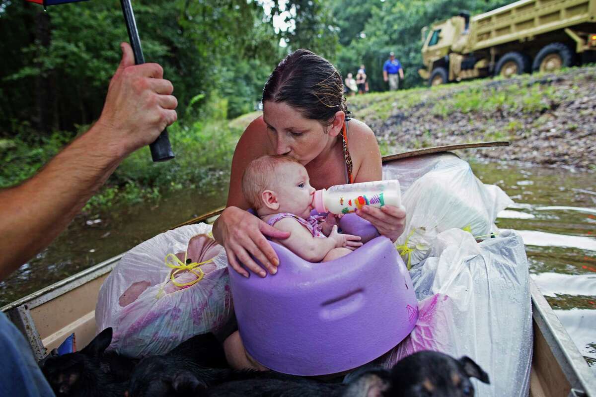 Danielle Blount kisses her 3-month-old baby, Ember, as she feeds her. They are waiting to be evacuated by members of the Louisiana Army National Guard, near Walker, La. (For more photos from the flood, scroll through the slideshow.)