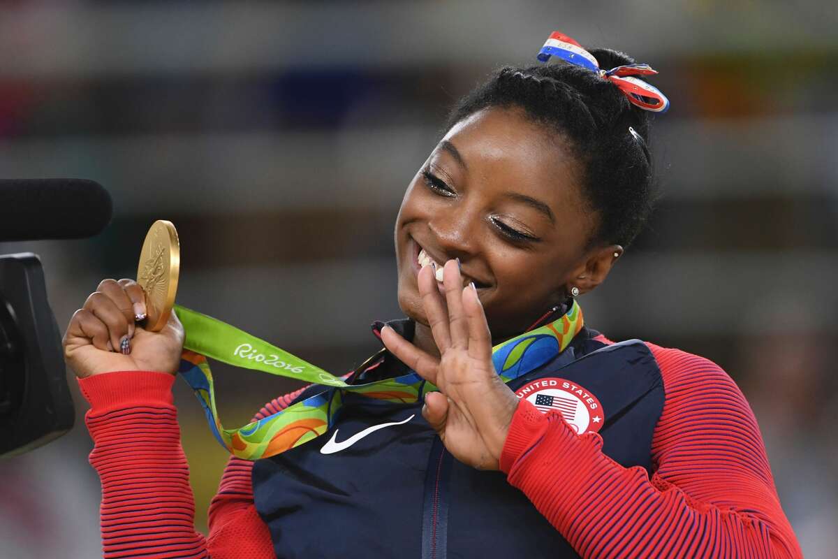 US gymnast Simone Biles celebrates on the podium of the women's floor event final of the Artistic Gymnastics at the Olympic Arena during the Rio 2016 Olympic Games in Rio de Janeiro on August 16, 2016. / AFP / Toshifumi KITAMURA (Photo credit should read TOSHIFUMI KITAMURA/AFP/Getty Images)