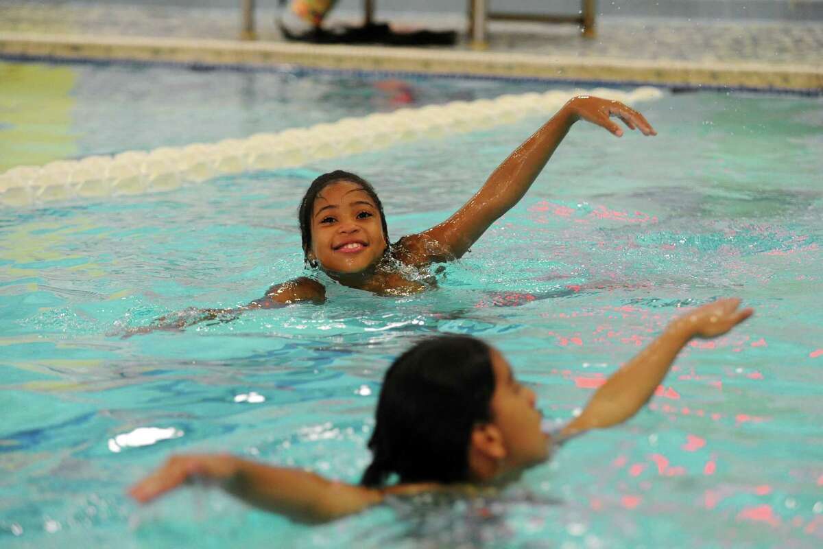 10-year-old Janaiya Malachi, above, practices swimming with 10-year-old Flor Lopez during the ZAC Camp inside the YMCA in Stamford, Conn. on Tuesday, August 16, 2016. Both girls got into the pool for the first time on Monday without knowing how to swim.