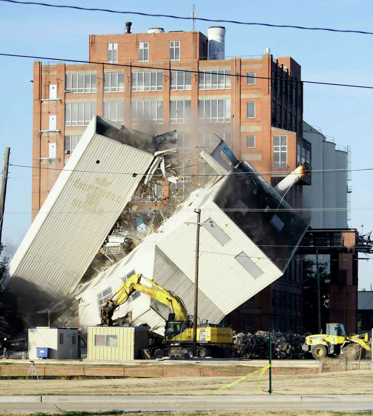 The furnace house of the historic Imperial Sugar Company refinery eventually falls Sunday, Dec. 19, 2010, in Sugar Land. There was no warning when the building fell and many people in the crowd thought there were people in it. The bin building and furnace house are being removed to make way for improvements to the historic site including mixed use building that will have retail and apartments. ( Nick de la Torre / Houston Chronicle )