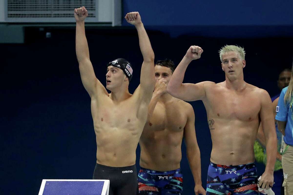 Jimmy Feigen (far right), Ryan Held and Blake Pieroni of the United States celebrate winning heat two of the men’s 400-meter freestyle relay on Day 2 of the 2016 Rio Olympic Games at the Olympic Aquatics Stadium on Aug. 7.