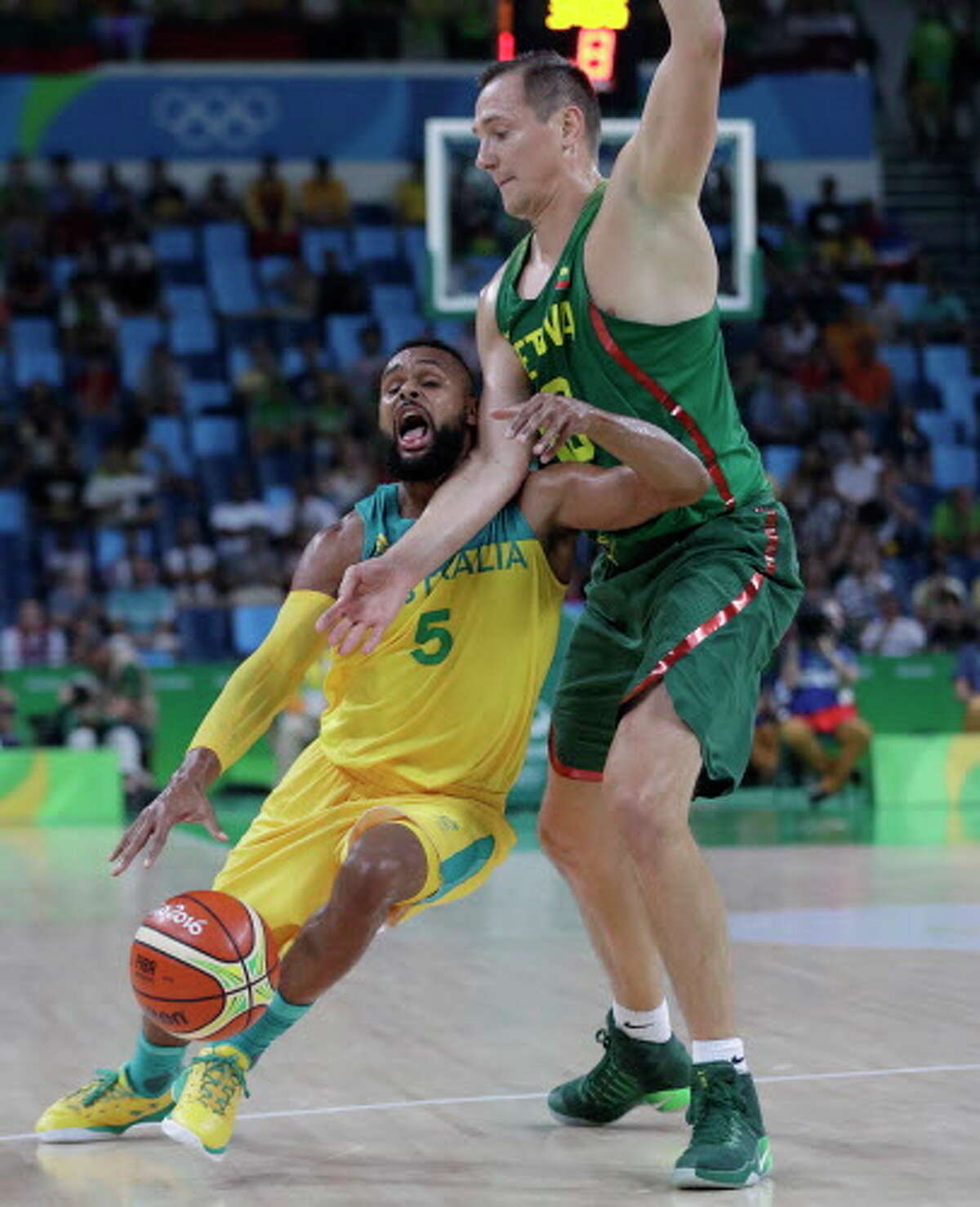 Australia's Patty Mills (5) is fouled by Lithuania's Paulius Jankunas (13) during a men's quarterfinal round basketball game against Australia at the 2016 Summer Olympics in Rio de Janeiro, Brazil, Wednesday, Aug. 17, 2016. (AP Photo/Eric Gay)