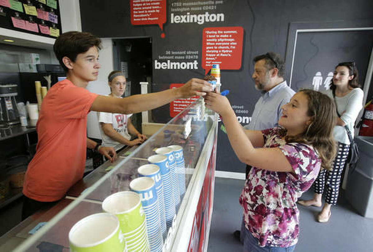 In this Tuesday, Aug. 2, 2016 photo, worker Nick Tzannes, left, of Lexington, Mass., serves ice cream to Magnolia Keller-Deutsch, front right, of Needham, Mass., at the pop-up ice cream shop Rancatore's Ice Cream & Yogurt in Newton, Mass. Entrepreneurs increasingly are taking the “pop-up” concept in new and unexpected directions. (AP Photo/Steven Senne)