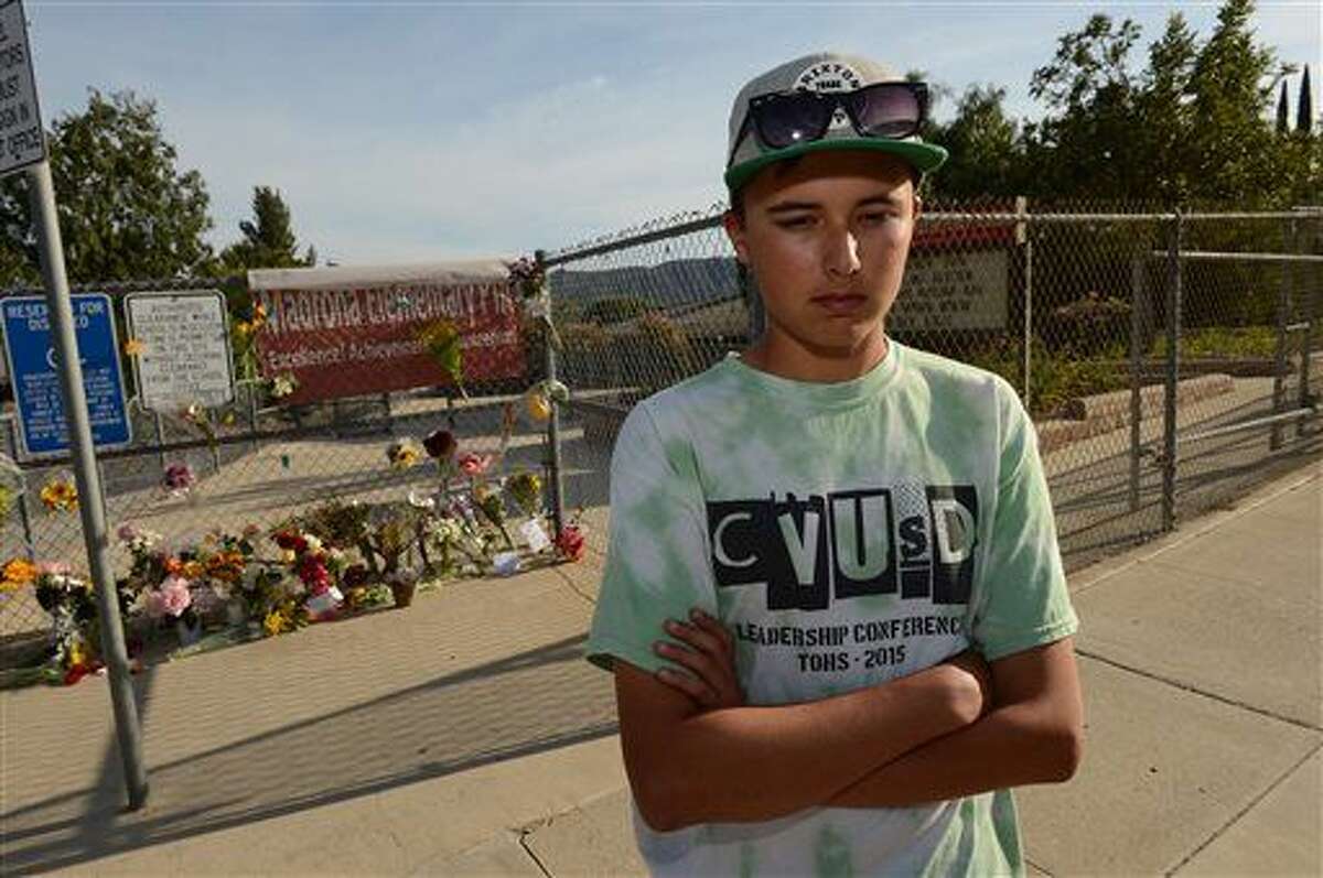 Seth Gregory, a classmate and friend, visits the memorial site of Bernard Moon, 18, at Madrona Elementary School on Tuesday evening, April 5, 2016, in Thousand Oaks, Calif. Investigators on Tuesday were trying to figure out what caused a homemade rocket attached to a skateboard to explode, killing a Southern California high school student and injuring his friend. Moon, of Thousand Oaks died after the blast Monday night. A 17-year-old had minor injuries and was released from the hospital Tuesday. (Karen Qunicy Loberg/The Ventura County Star via AP)