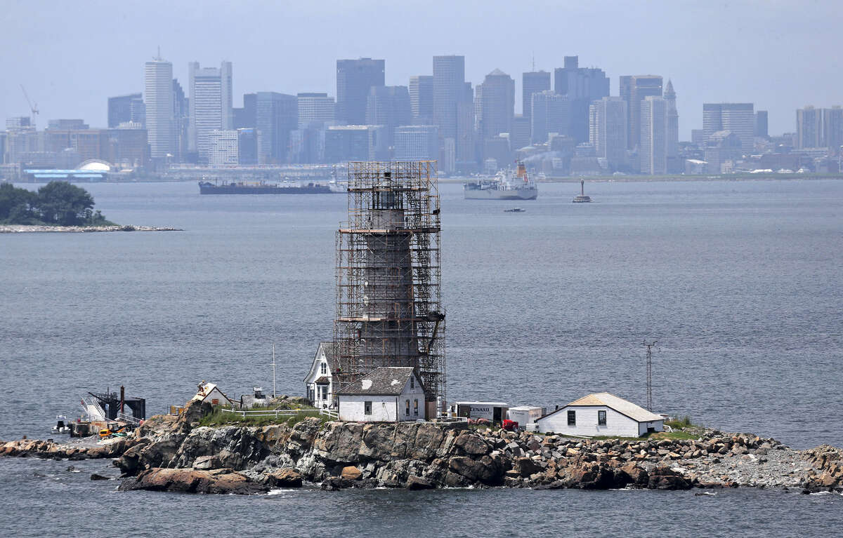 FILE -- In this July 28, 2014 file photo, scaffolding surrounds Boston Light, an historic 18th century lighthouse in Boston Harbor, as crews renovate the structure. The nation's first and oldest lighthouse, and the U.S. Coast Guard's last manned station, is celebrating 300 years of warning mariners as they navigate the tricky waters of Boston Harbor. (AP Photo/The Boston Globe, David L. Ryan, File) BOSTON HERALD OUT, QUINCY OUT; NO SALES /The Boston Globe via AP) BOSTON HERALD OUT, QUINCY OUT; NO SALES; MANDATORY CREDIT