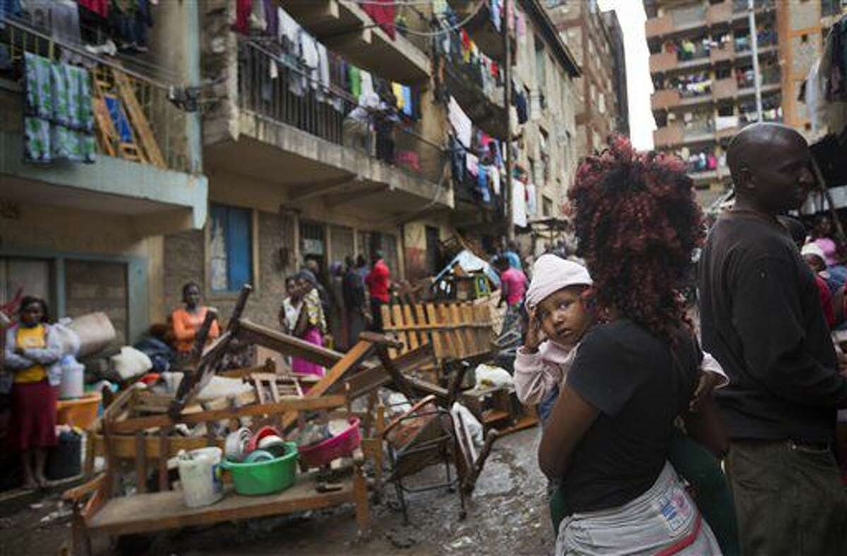 A woman holds a baby as residents are evicted from their apartment blocks close to the site of last week's building collapse, after their homes were deemed unfit for habitation and marked for demolition, in the Huruma neighborhood of Nairobi, Kenya, Friday, May 6, 2016. As emergency workers retrieved more bodies from a building that collapsed a week ago, bringing the death toll to 41, hundreds of residents were evicted from nearby buildings that are being torn down to prevent other disasters. (AP Photo/Ben Curtis)