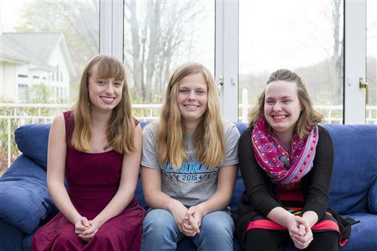 This April 30, 2016 photo shows Baye Lee, Allie and Jenna Braschler in their home in Grand Rapids. Triplets born 15 weeks premature in 1997 are set to graduate at their top of their class at Saugatuck High School in late May. The trio has also served as class president, vice president and treasurer in their senior year, among other activities. (Nick Gonzales/The Grand Rapids Press via AP)