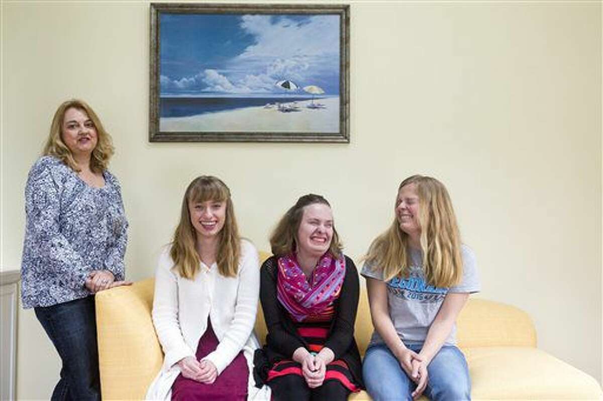 In this April 30, 2016 photo, Barrie Braschler stands next to her daughters, from left, Baye Lee, Jenna and Allie in their home in Grand Rapids. Triplets born 15 weeks premature in 1997 are set to graduate at their top of their class at Saugatuck High School in late May. The trio has also served as class president, vice president and treasurer in their senior year, among other activities. (Nick Gonzales/The Grand Rapids Press via AP)