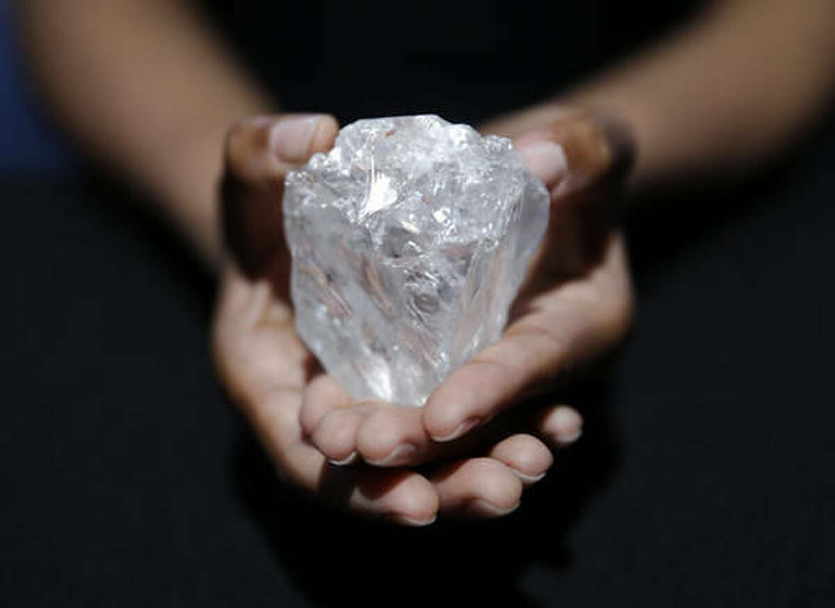 A model displays a large diamond at Sotheby's in New York, Wednesday, May 4, 2016. A 3-billion-year-old diamond the size of a tennis ball — the largest discovered in over a century — could sell for more than $70 million, auctioneer Sotheby's said Wednesday. The auction house plans to offer the Lesedi la Rona diamond in London on June 29. (AP Photo/Seth Wenig)