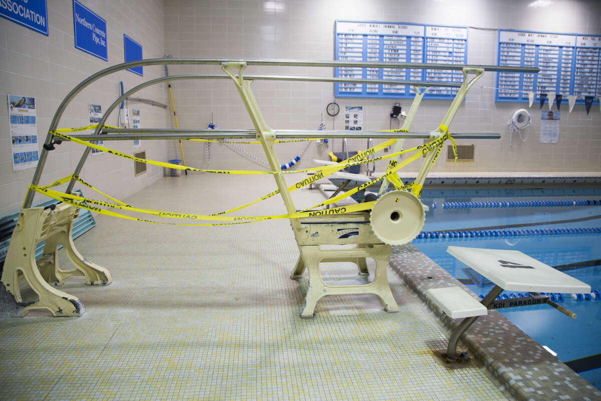 The dive board is taped off as a safety hazard Thursday April 7, 2016, at Garber High School in Hampton Township, Mich. The community is pulling together to raise money to fix up a high school pool. Superintendent Matthew Cortez says it may cost about $600,000 to fix pipes, the pool deck and the structure supporting the pool so it can be used past this year. He says it could cost as much as $1.8 million to completely revamp the 50-year-old pool to modern standards. (Gavin McIntyre/The Bay City Times via AP) LOCAL TELEVISION OUT; LOCAL INTERNET OUT; MANDATORY CREDIT