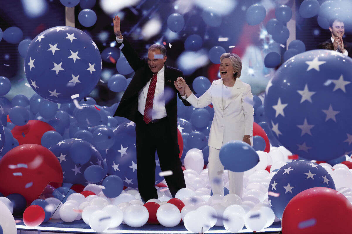 Democratic vice presidential nominee Sen. Tim Kaine, D-Va., and Democratic presidential nominee Hillary Clinton walk through the falling balloons during the final day of the Democratic National Convention in Philadelphia , Thursday, July 28, 2016. (AP)