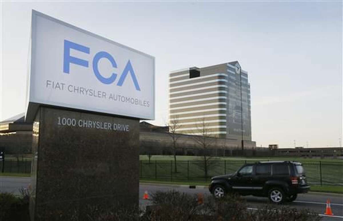 In this Tuesday, May 6, 2014, file photo, a vehicle moves past a sign outside Fiat Chrysler Automobiles world headquarters in Auburn Hills, Mich. Federal prosecutors are investigating allegations that Fiat Chrysler violated securities laws by getting dealers to falsely report sales in order to inflate the company’s numbers. The company says in a statement that it’s cooperating with an investigation by the Securities and Exchange Commission and that it has received similar inquiries from the Justice Department. (AP Photo/Carlos Osorio)