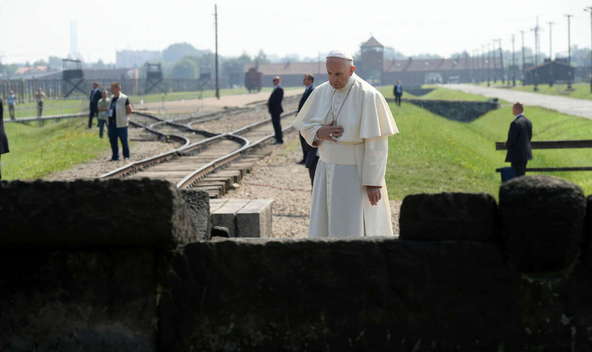 Pope Francis prays in front of the Memorial at the former Nazi Death Camp Auschwitz-Birkenau, in Oswiecim, Poland, Friday, July 29, 2016. Pope Francis paid a somber visit to the Nazi German death camp of Auschwitz-Birkenau Friday, becoming the third consecutive pontiff to make the pilgrimage to the place where Adolf Hitler's forces killed more than 1 million people, most of them Jews. (L'Osservatore Romano /Pool Photo via AP)