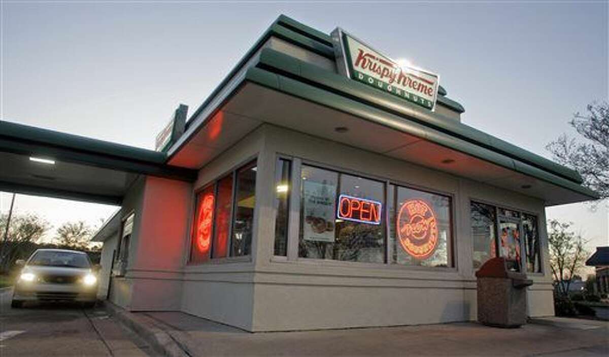 In this April 17, 2008, file photo, a customer picks up doughnuts at the drive through at a Krispy Kreme store in Matthews, N.C. Krispy Kreme is being taken private by JAB Beech in a deal announced Monday, May 9, 2016. (AP Photo/Chuck Burton)