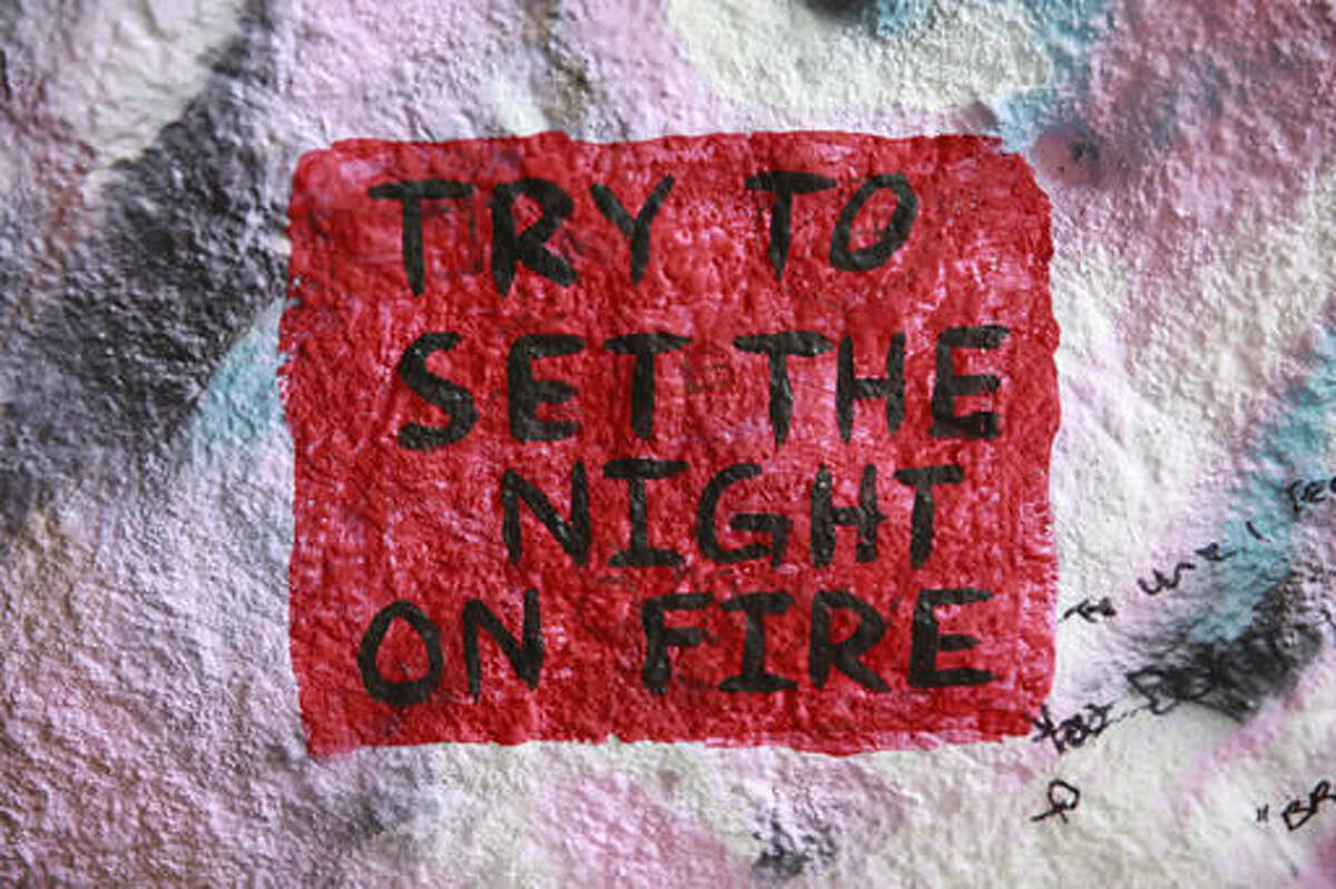 A graffiti reads "Try to set the night on fire," a lyric from The Doors rock band inside the Corral Canyon Cave at Corral Canyon Cave in Malibu, Calif., Friday, May, 6, 2016.The cave, better known by the misleading moniker "Jim Morrison Cave" is now closed to the public until further notice. Large crowds have shown up on a daily basis to see the often vandalized cave and in some cases add to the vandalism with graffiti of their own. (AP Photo/Damian Dovarganes)