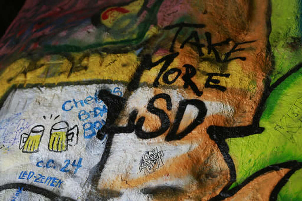 Graffiti with alcohol and drugs themes is seen inside the Corral Canyon Cave at Corral Canyon Cave in Malibu, Calif., Friday, May, 6, 2016. As the Doors song goes, this is the end. Fans of the band who have marked up a scenic cave on the California coast with psychedelic graffiti will have to find another place to spray out their love for front man Jim Morrison. (AP Photo/Damian Dovarganes)