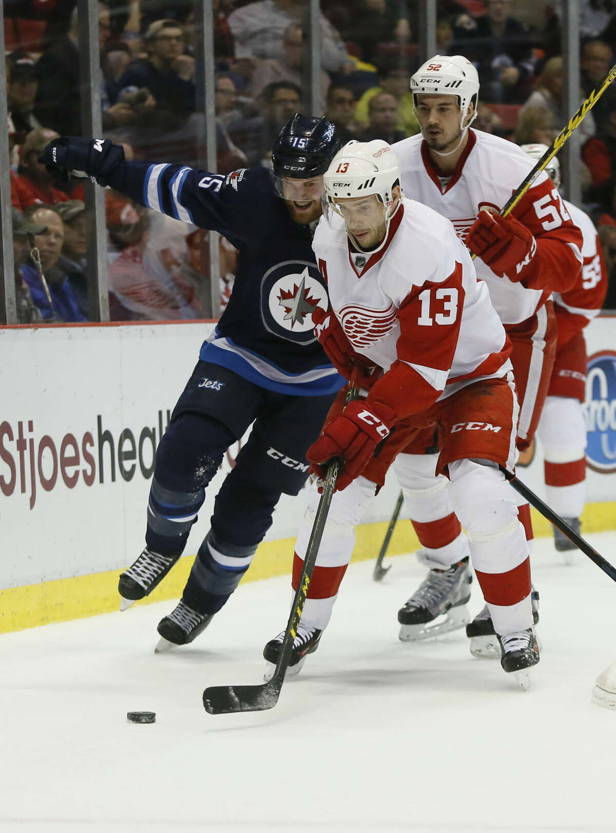 Detroit Red Wings' Pavel Datsyuk (13), of Russia, is pursued by Winnipeg Jets' Matt Halischuk (15) as Detroit Red Wings' Jonathan Ericsson (52), of Sweden, follows during the first period of an NHL hockey game Thursday, March 10, 2016, in Detroit. (AP Photo/Duane Burleson)