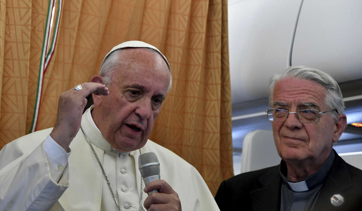 Pope Francis, flanked by Vatican spokesman Federico Lombardi, right, talks to journalists during a press conference he held on board the airplane on his way back to the Vatican, at the end of three-day visit to Armenia, Sunday, June 26, 2016. (Tiziana Fabi/Pool photo via AP)