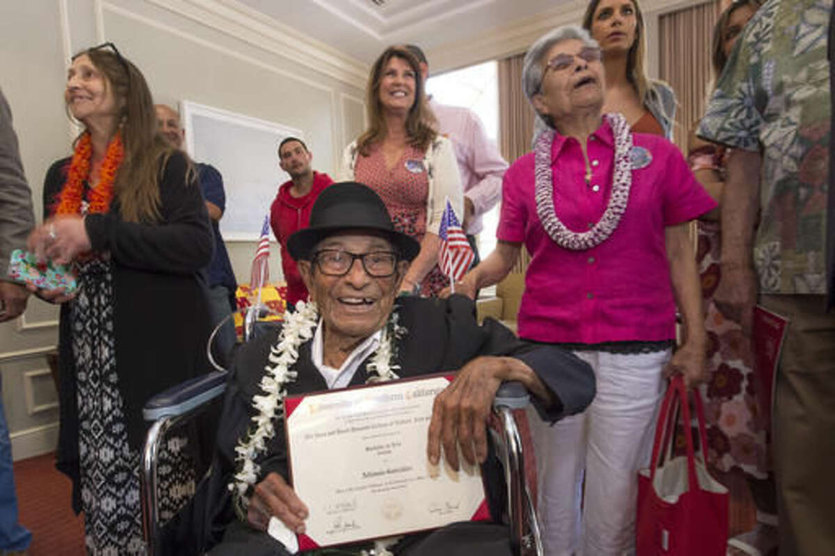 Alfonso Gonzales, 96, University of Southern California's oldest graduating Trojan receives his Bachelor of Science degree in zoology diploma from USC surrounded by family members, as part of the 2016 USC Commencement ceremony, on Friday, May 13, 2016 in Los Angeles. The World War II veteran thought he'd already graduated when he skipped commencement exercises in 1953 because of work obligations. He was founding a soil company that he ran for 55 years. But when relatives recently approached USC about getting a copy of his diploma, they learned he was one unit short. Although the school no longer offers a zoology major, it crafted an independent study course through the gerontology school that included reading, video assignments, visiting other classes, and writing a thesis about his life. (Gus Ruelas/USC via AP)