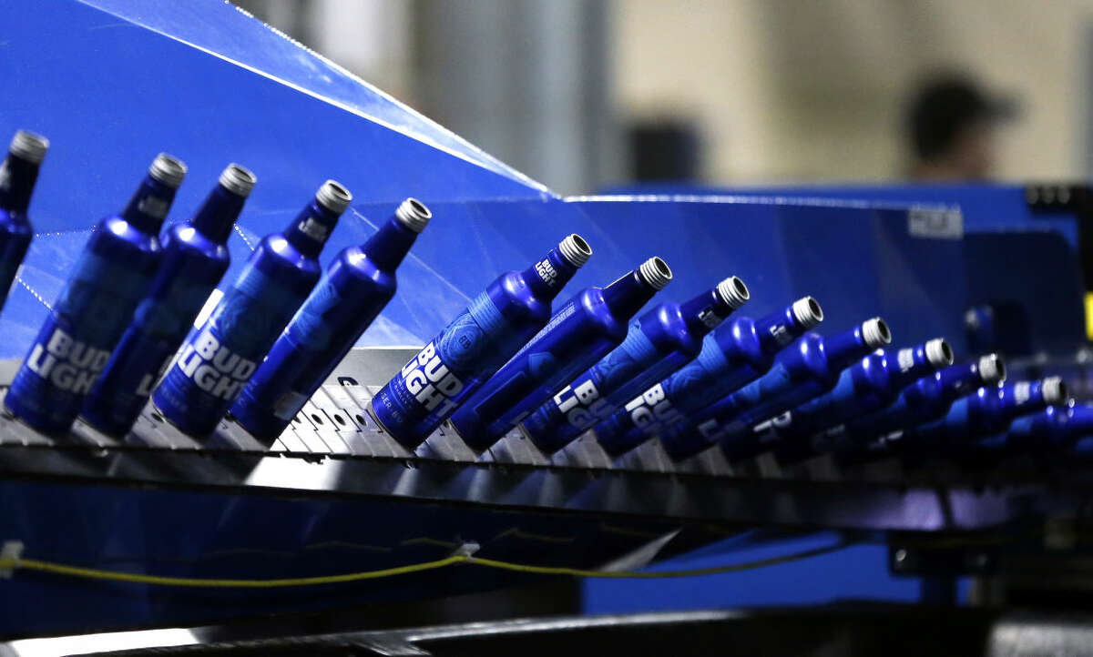 FILE - In this Friday, April 8, 2016, file photo, aluminum Bud Light bottles move along a conveyor at a plant manufacturing 16-ounce Budweiser and Bud Light aluminum bottles for Anheuser-Busch, in Arnold, Mo. On Friday, April 15, 2016, the Federal Reserve reports on U.S. industrial production for March. (AP Photo/Jeff Roberson, File)
