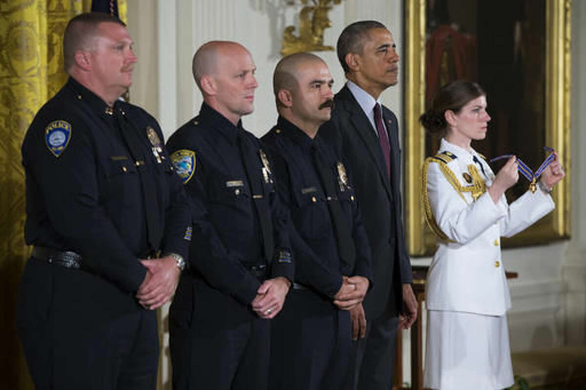 President Barack Obama stands with, from left, Santa Monica College Police Department Capt. Raymond Bottenfield, and Santa Monica, Calif. Police Department officers Robert Sparks, and Jason Salas during the Medal of Valor ceremony in the East Room of the White House in Washington, Monday, May 16, 2016. The Medal of Valor is awarded to public safety officers who have exhibited exceptional courage, regardless of personal safety, in the attempt to save or protect others from harm.(AP Photo/Evan Vucci)