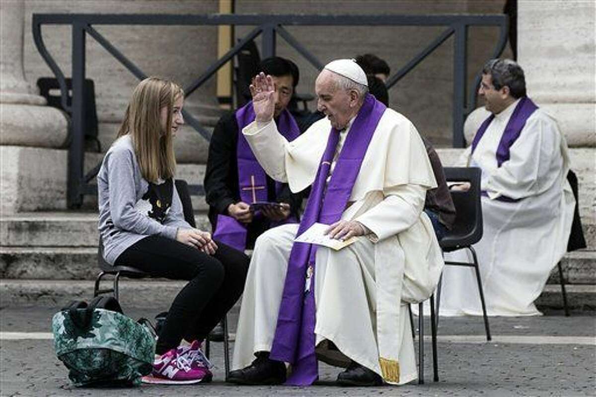 Pope Francis confesses a young faithful during the Youth Jubilee at Saint Peter square in Vatican, Saturday, April 23, 2016. Sixteen teenagers have gotten an unexpected opportunity to confess sins to Pope Francis. The pontiff made a surprise appearance in St. Peter’s Square, where thousands were participating in Holy Year youth activities, with confession outdoors at the Vatican. (Angelo Carconi/ANSA via AP Photo)