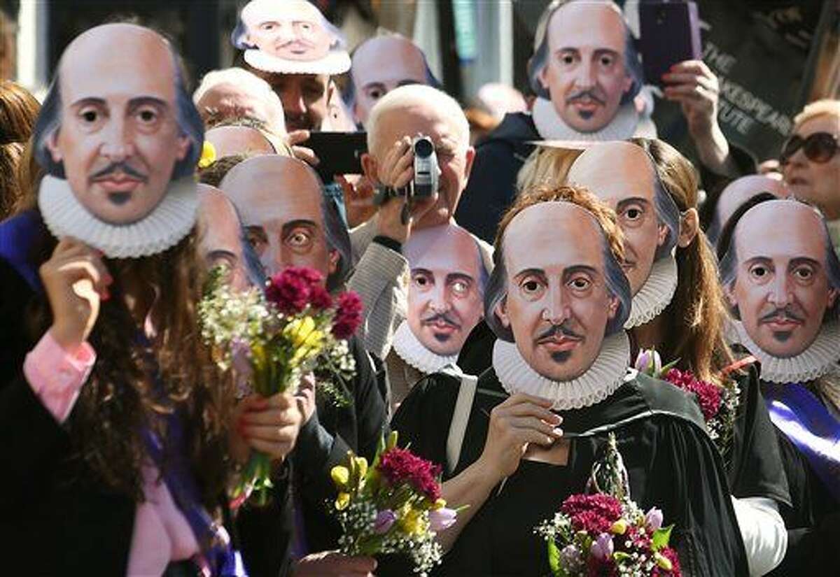 Members of the public wear William Shakespeare masks during a parade marking 400-years since the death of the playwright in Stratford-upon-Avon, England, Saturday April 23, 2016. The legacy of Shakespeare, who is buried in Stratford's Holy Trinity Church, will be brought to life by a host of actors, dancers and theatrical extras, including local schoolchildren and the public who are gathering to mark the anniversary of the bard's death. (Joe Giddens / PA via AP)