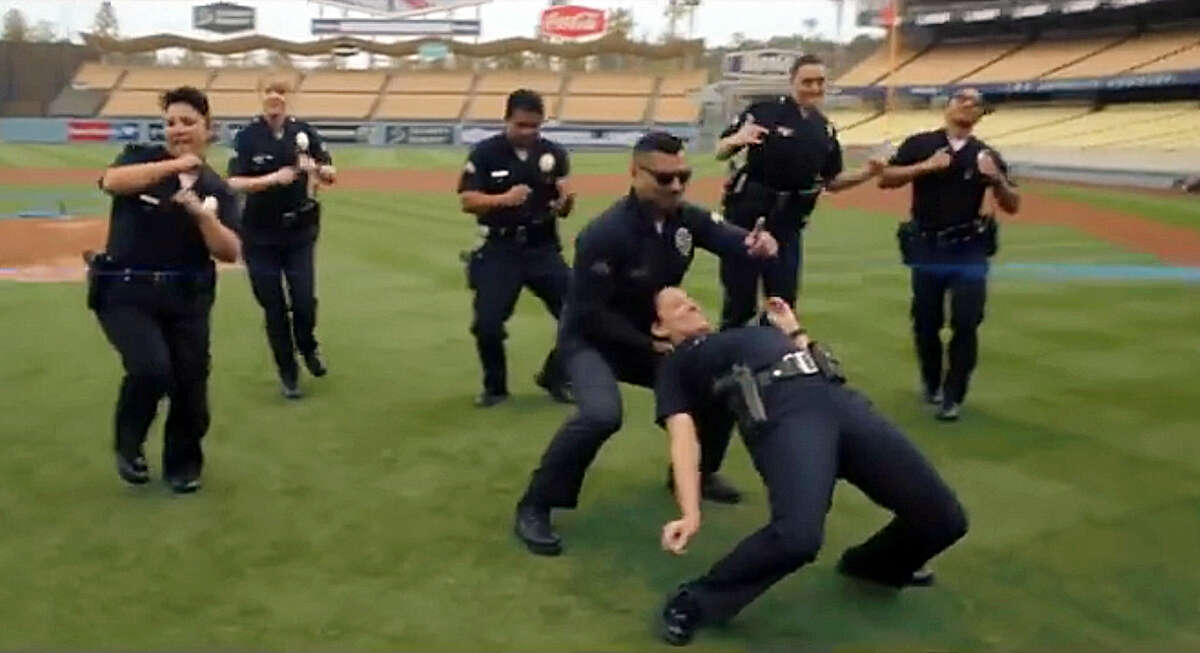 In this undated frame from video provided by the Los Angeles Police Department, LAPD officers dance on the field at Dodger Stadium in Los Angeles. In a now-viral sensation, police officers across the U.S. are dancing an updated version of the running man to a catchy 1990s hip hop song, "My Boo" by Ghost Town DJ's, in videos that have included professional sports mascots, cheerleading squads and at least one explosion. The videos started with the New York Police Department and are getting more elaborate and popular, with even some police chiefs joining in. (Los Angeles Police Department via AP) MANDATORY CREDIT