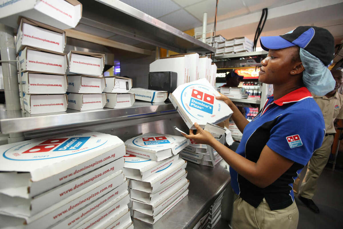 FILE - In this Sunday, Feb. 10, 2013, file photo, a worker prepares boxes at a Domino's pizza restaurant in Lagos, Nigeria. Domino's Pizza reports financial results Thursday, April 28, 2016. ( AP Photo/Sunday Alamba, File)