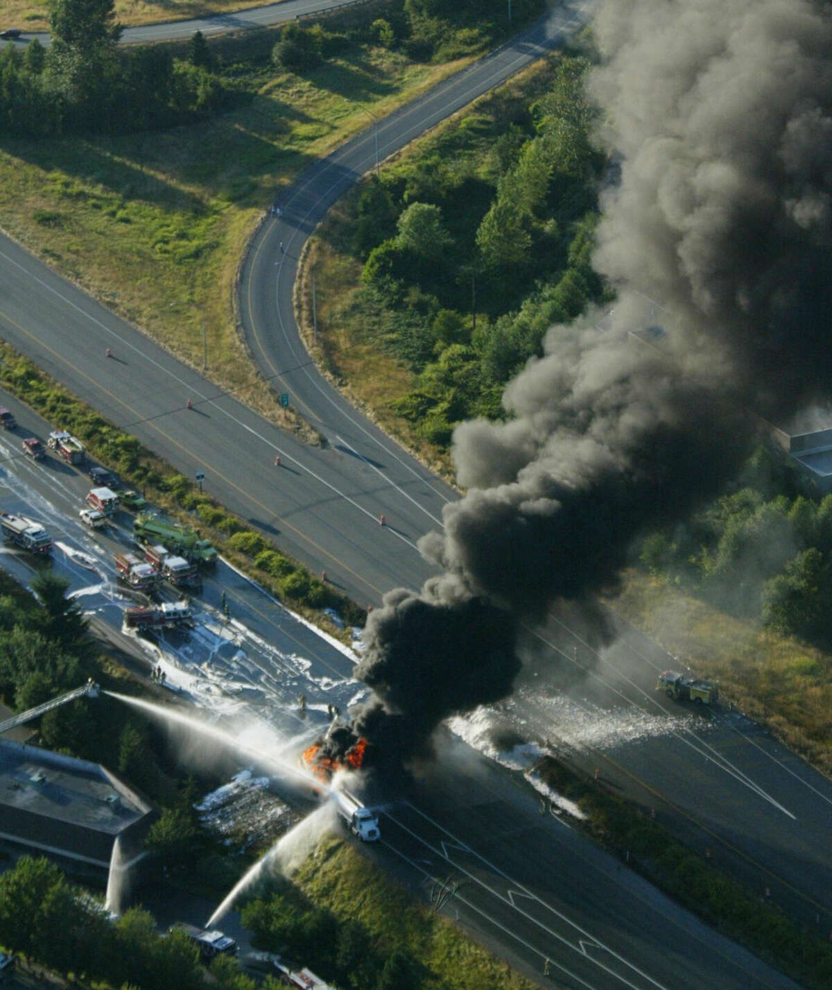 In this aerial photo taken July 16, 2002, firefighting foam is used in an attempt to extinguish a burning fuel tanker truck on Interstate 90 in Issaquah, Wash. The accident took place near one of several wells that supply drinking water to the city of Issaquah. That well is now contaminated and not in use, but the city says it has not confirmed the source of the contamination. The city will install a filtration system on the well by the summer of 2016. (Harley Soltes/The Seattle Times via AP) SEATTLE OUT; USA TODAY OUT; MAGS OUT; TELEVISION OUT; NO SALES; MANDATORY CREDIT TO BOTH THE SEATTLE TIMES AND THE PHOTOGRAPHER